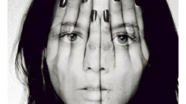 Girl with transparent hands over face. Black and white photo.