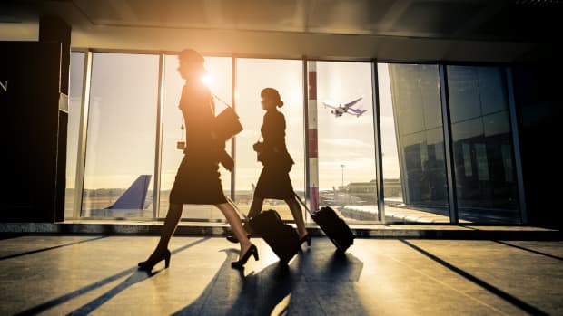 Silhouette of two female pilots with luggage walking through the airport