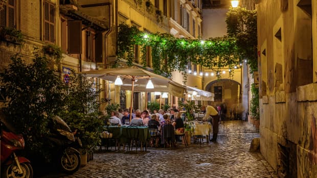 Diners having dinner under the night sky on a cobblestone street in Rome, Italy