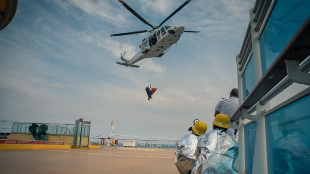 A paramedic helicopter airlifts a patient off the deck of a cruise ship