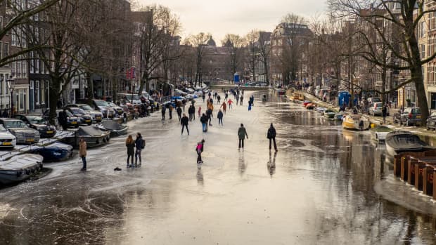 People ice skating on a canal in Amsterdamn