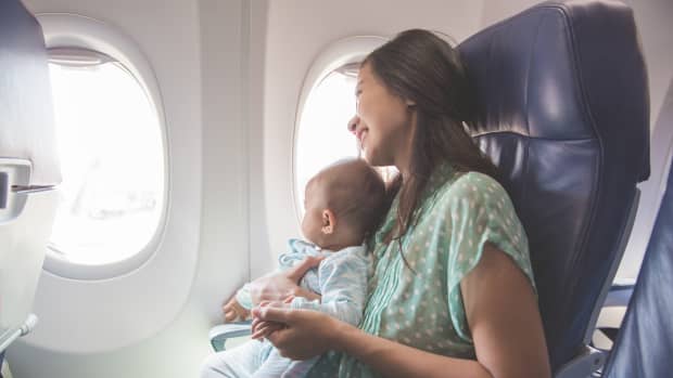 A mother and baby looking out their airplane window