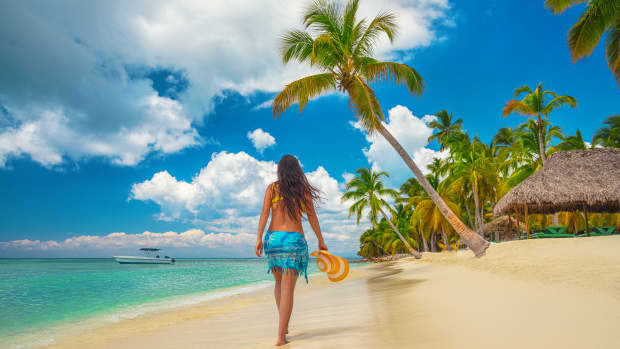 A woman walking away from the camera on a Caribbean beach