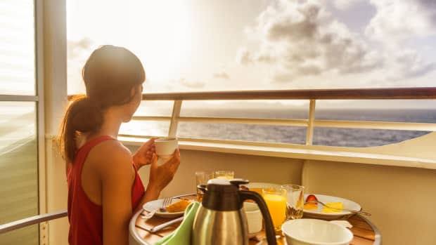 A woman takes her early morning breakfast on a cruise ship balcony