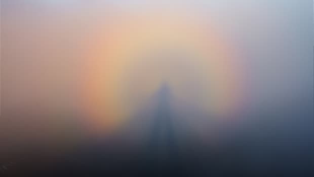 the atmospheric phenomenon known as a Brocken Spectre, a rainbow halo of light around an enormous shadow figure of the observer