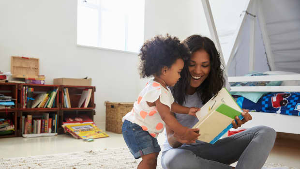 baby reading book with mom