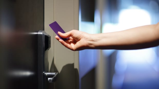 A woman using a purple keycard to open a hotel door