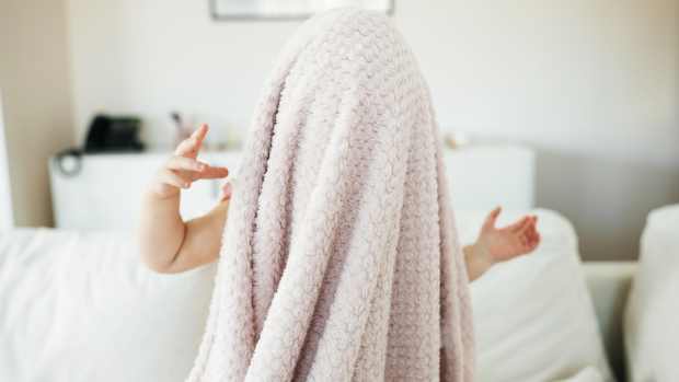 toddler with blanket on head