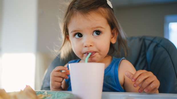 baby girl drinking from straw