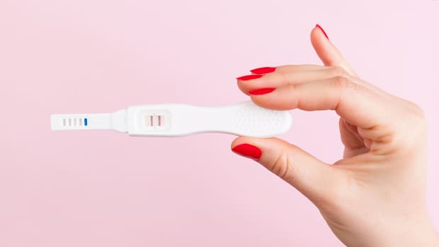 woman holding positive pregnancy test