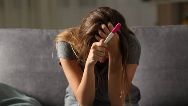 woman crying with pregnancy test