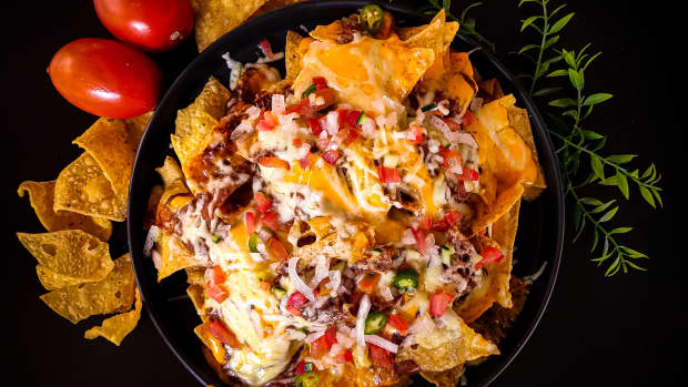 Nachos with meat, cheese, onions, and tomato