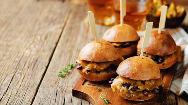 Four cheeseburger sliders on a tray