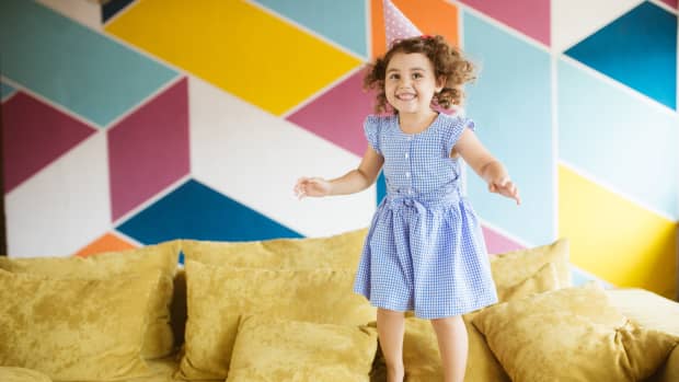 little girl jumping on couch
