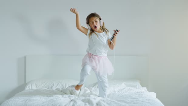 little girl dancing on bed