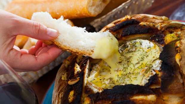 A bread bowl with melted cheese.