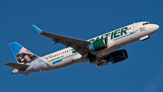 A Frontier Airlines plane in a blue sky