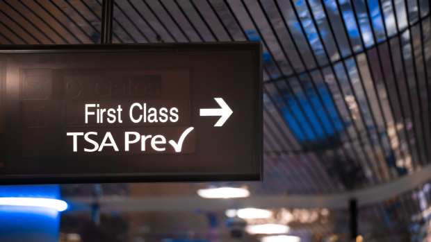 Airport sign indicating First Class and TSA Precheck security lanes