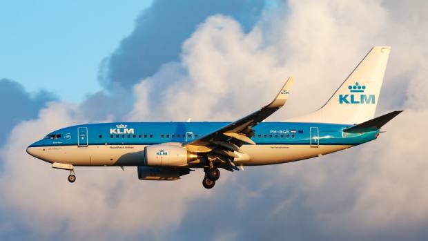 A KLM Airlines plane flying at sunset