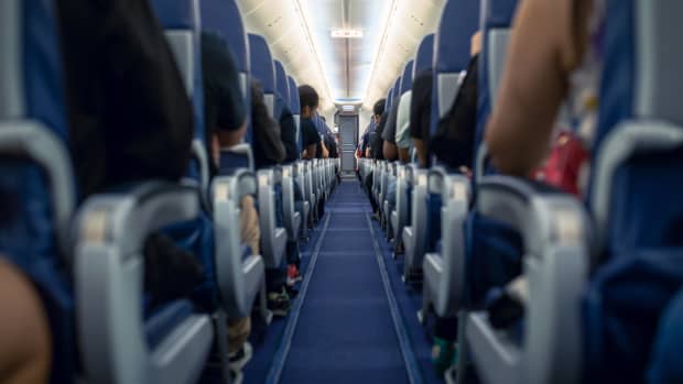 Airplane aisle with passengers in seats