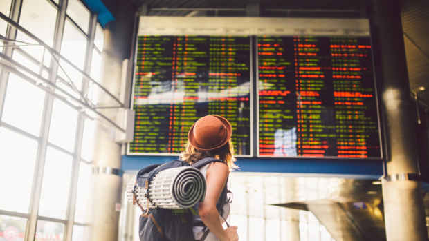 Young woman looking at an information board in an airport