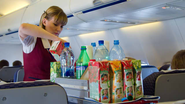 Flight attendant working beverage service during a flight