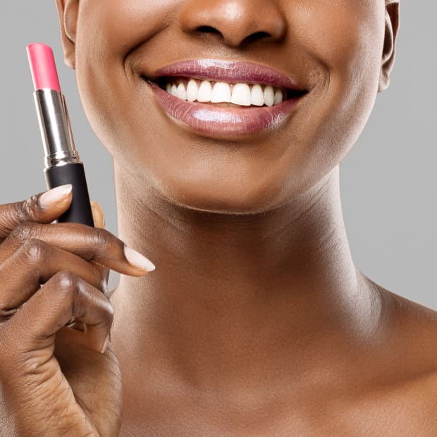 woman holds lipstick in her hand.