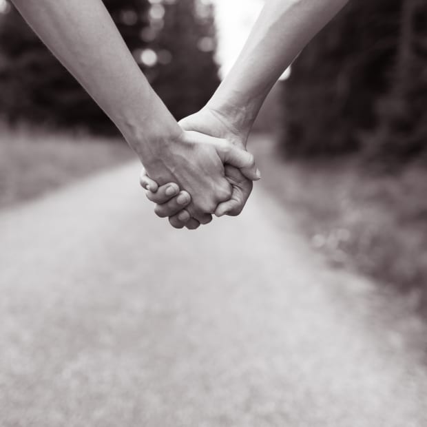 Couple walking while holding hands.