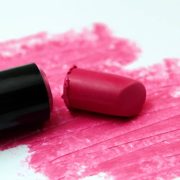 a close up of broken hot pink lipstick