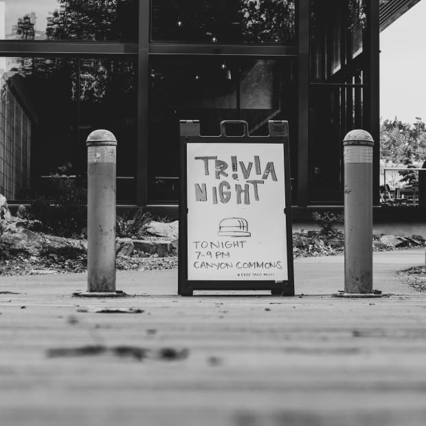 Black and white photo of sign advertising a trivia night