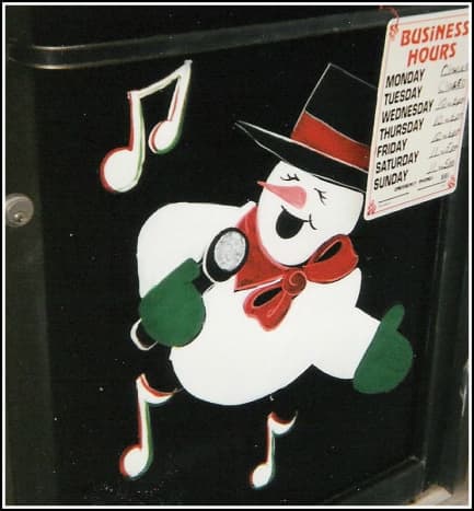 A singing snowman painted at the bottom of a door panel.