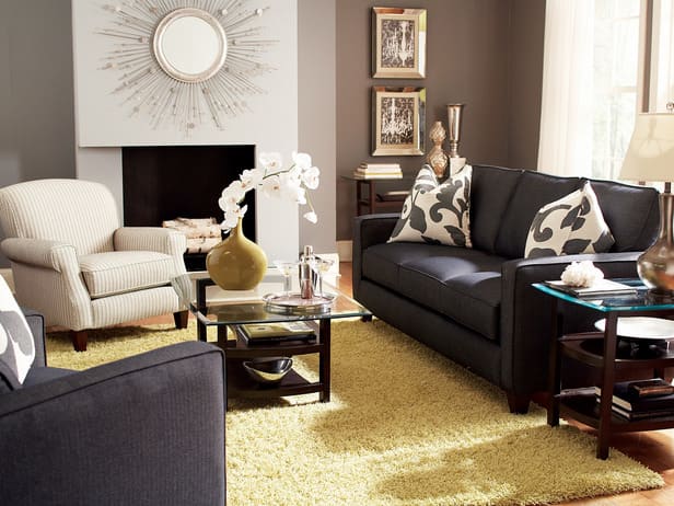 The gold of the area rug and vase here really make the couches pop, as well as the oversized pillows and wall colors.