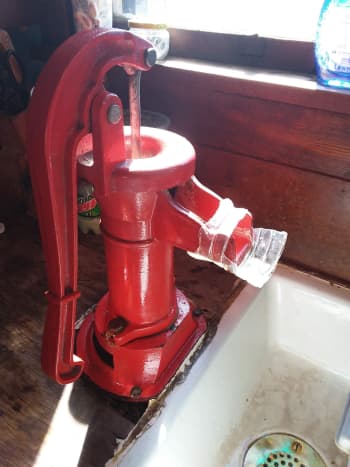 This pitcher pump drip guard is made from a plastic water bottle. 