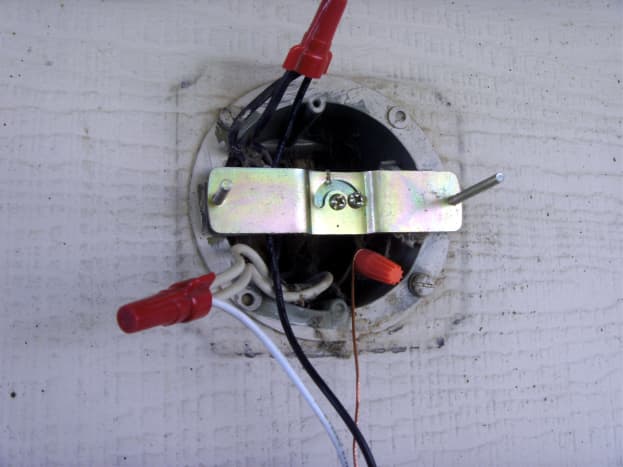 The wires were brought out past the bracket for easy splicing to the light.  Note that there are three wires in each nut; the two in the box are for an additional light located elsewhere.