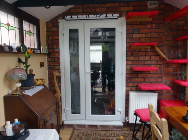 French doors, viewed from conservatory, with roller blind fitted above doorframe. 