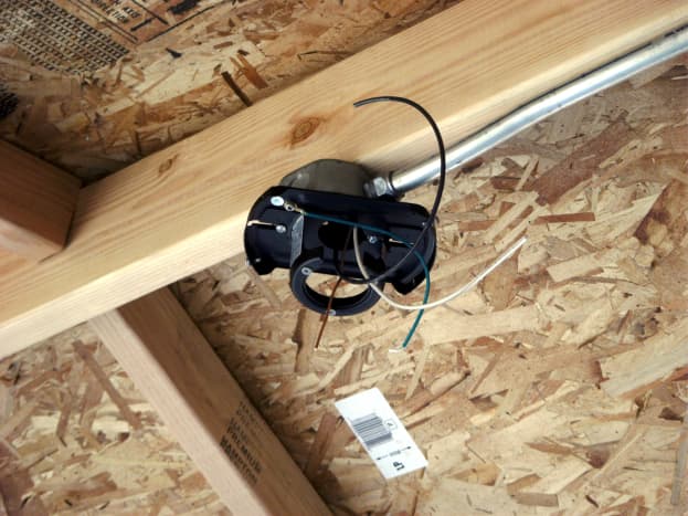 The ceiling bracket has been attached to the box and the wires routed through the bracket.
