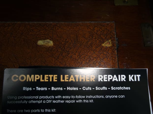 The two holes in the leather inlay that need to be repaired.