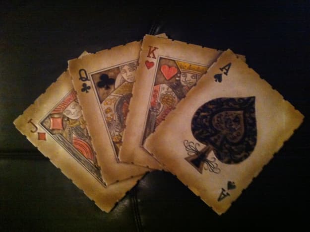 A decoration showing four playing cards.  Decorations like this can be used in playing card collections.