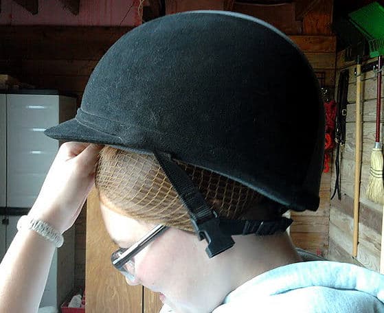 Step nine: Put helmet on over the hairnet back to front. 