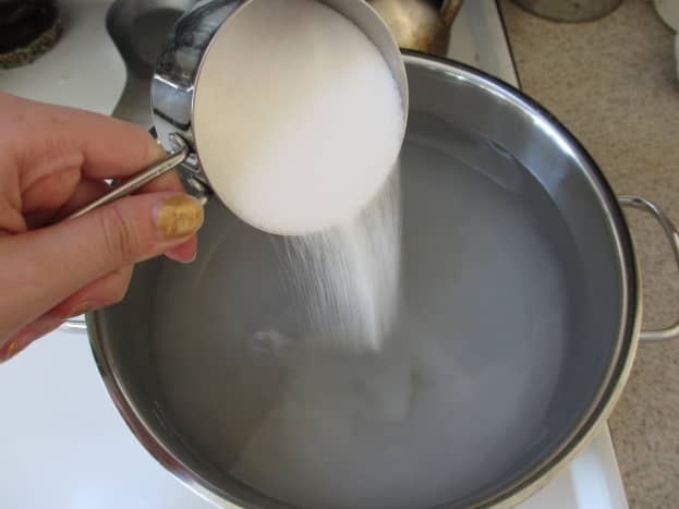 Pour one cup of salt into a large pot of water.
