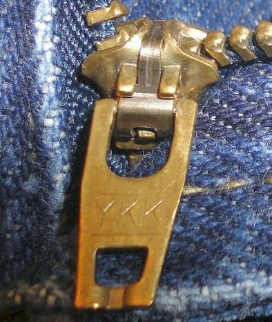 Close up of a genuine YKK zipper fastener. The YKK lettering could appear on both front &amp; rear of the slider hardware