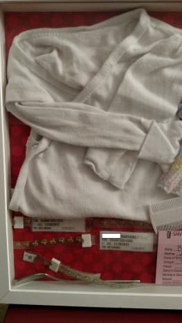 Hospital gown, wrist bands, and comb included in this shadow box detail