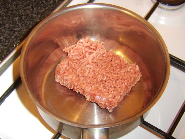 Beef is added to a dry pot.