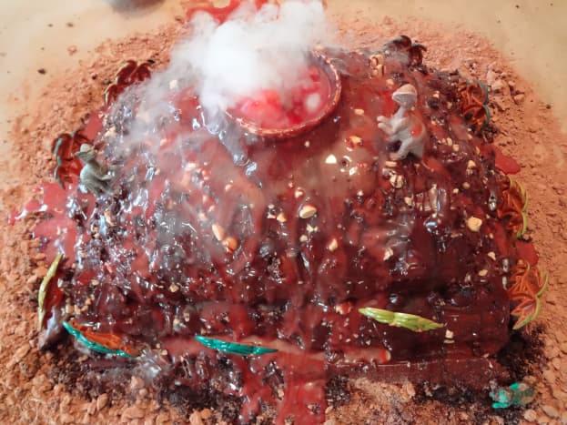 The lava is running down the sides of this smoking volcano cake.