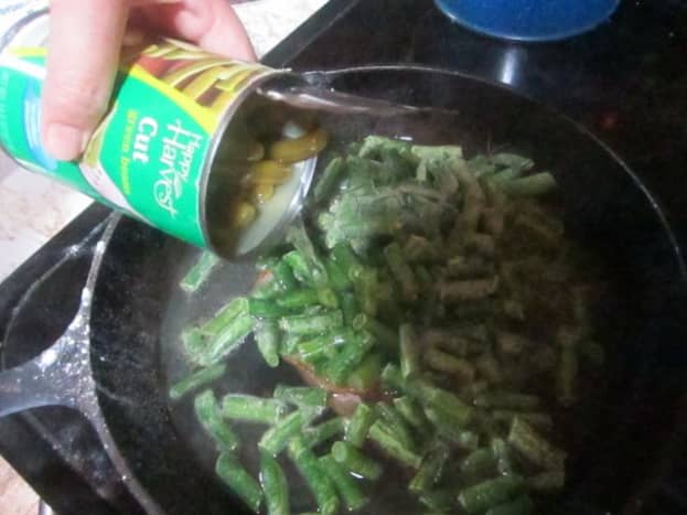 Add entire contents of one can of green beans to frozen ones.