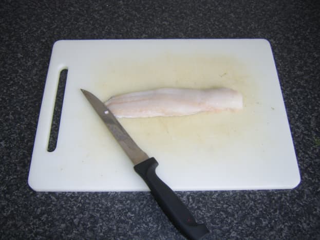 Fillet is laid on a chopping board, skin side down