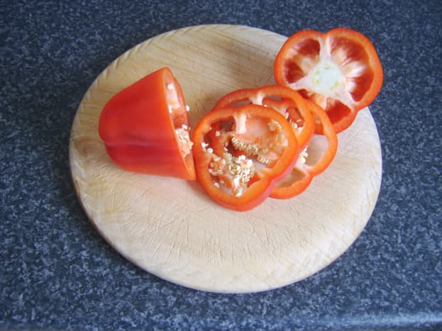Slices are cut from a red bell pepper