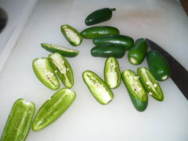 Wear gloves and slice the jalapeno peppers in half. Then remove most of the seeds. I leave some seeds in because I love the heat. 