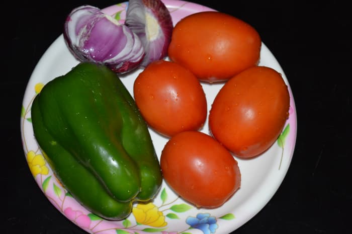 The vegetables used for making tomato and capsicum curry.