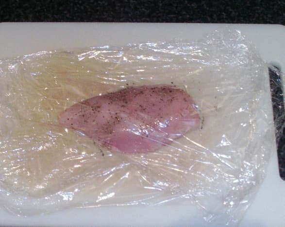 Seasoned chicken breast encased in plastic wrap